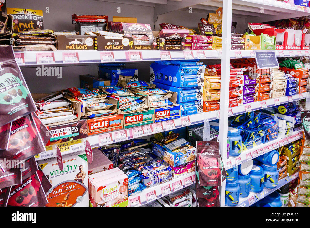 Shelves in a supermarket stocked with nut bars, energy bars, oat bars, protein bars and other health products. Stock Photo