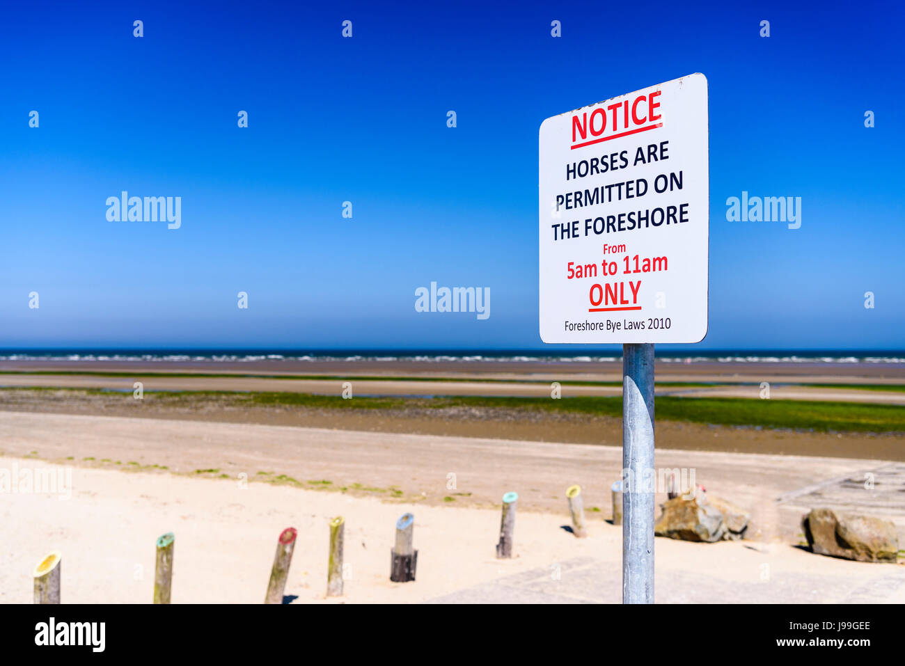 Sign at a beach, advising the public that horses are only permitted on the foreshore between 5am and 11am. Stock Photo