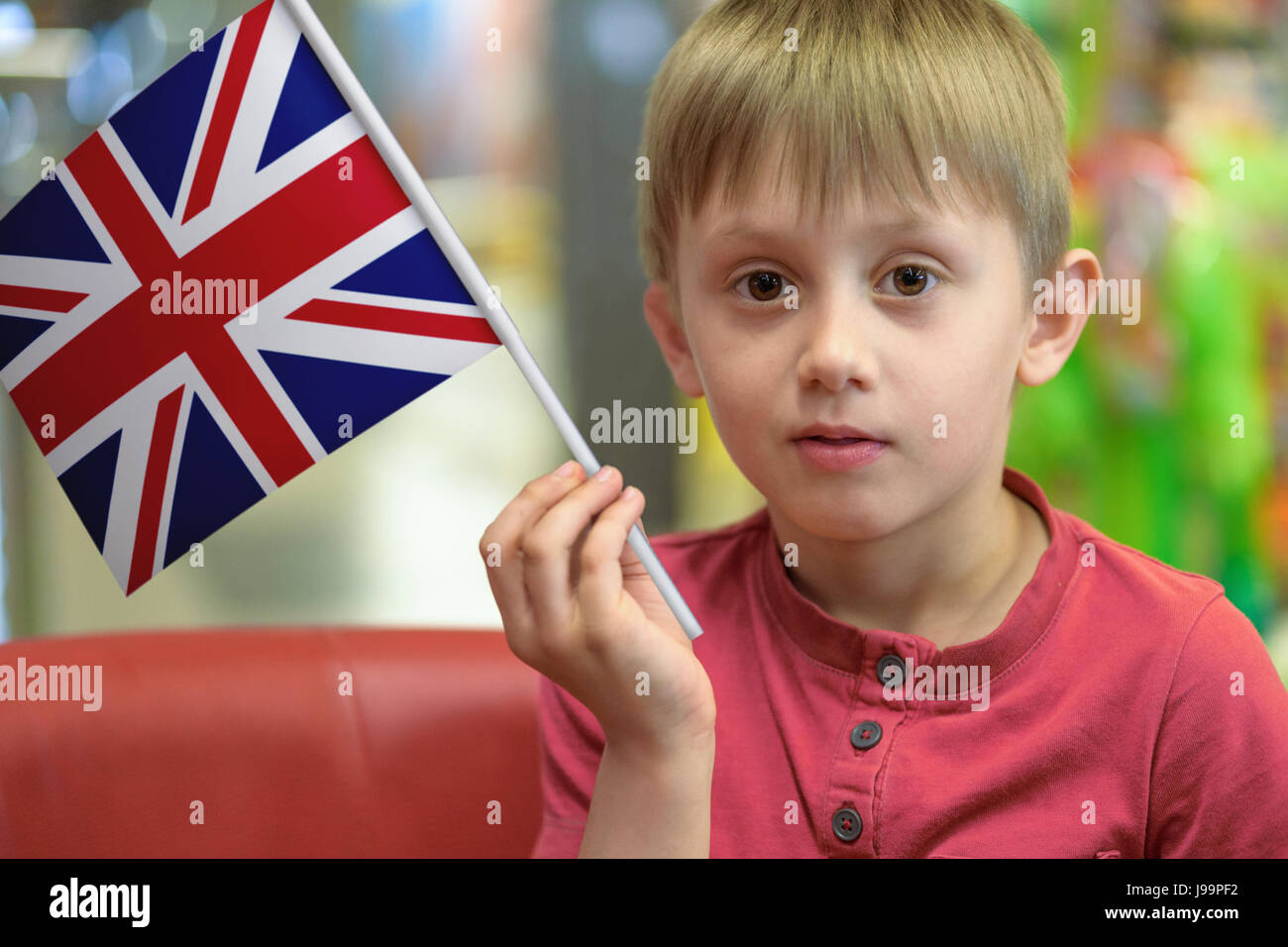Little boy as a patriot holding in his hand a paper flag of The United