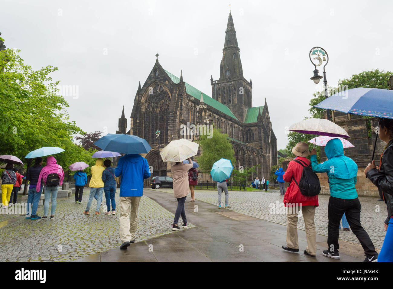 Glasgow, Scotland, UK. 1st June 2017. UK weather - colourful umbrellas outside Glasgow Cathedral on a grey showery day Credit: Kay Roxby/Alamy Live News Stock Photo