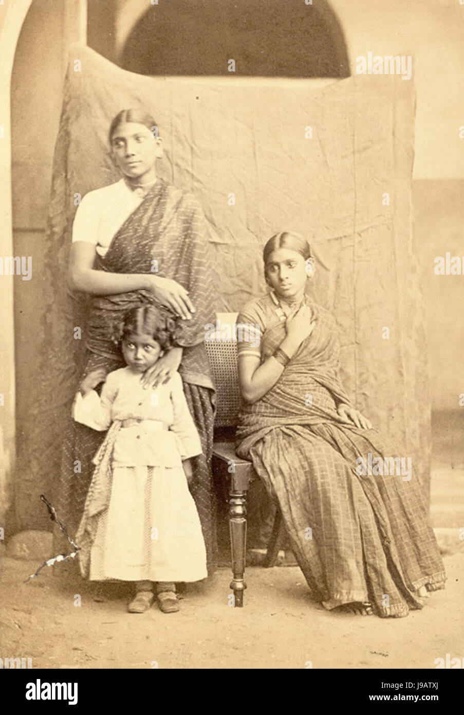 A photograph taken in 1867, showing two South Indian women and a child. The  image provides a glimpse into the traditional attire and daily life of South  Indian families during the 19th