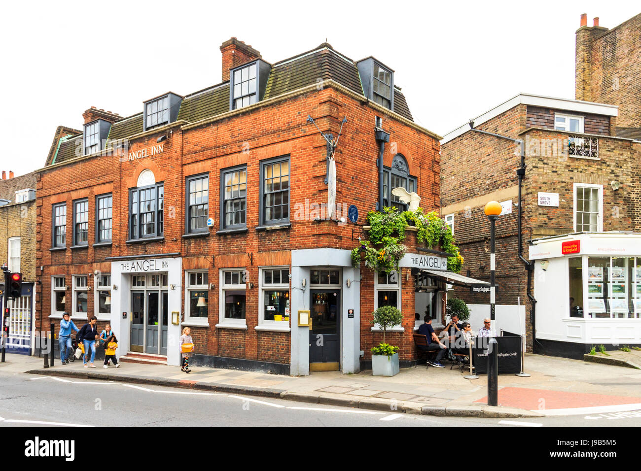 Customers drinking outside the historic Angel Inn in Highgate Village, London, UK Stock Photo