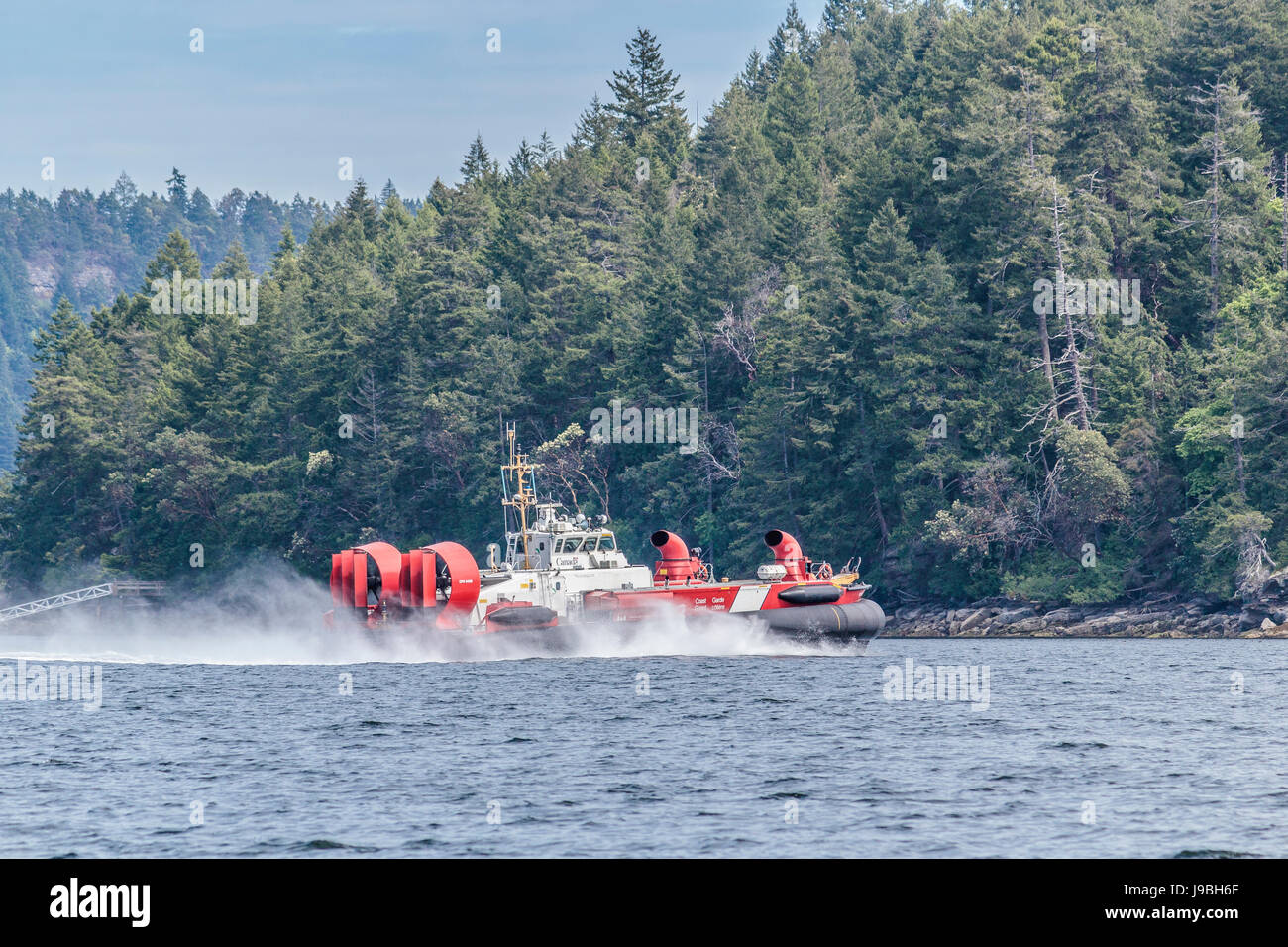 A Canadian Coast Guard hovercraft speeds alongside the shoreline of Ruxton Island, in British Columbia's Gulf Islands. Stock Photo