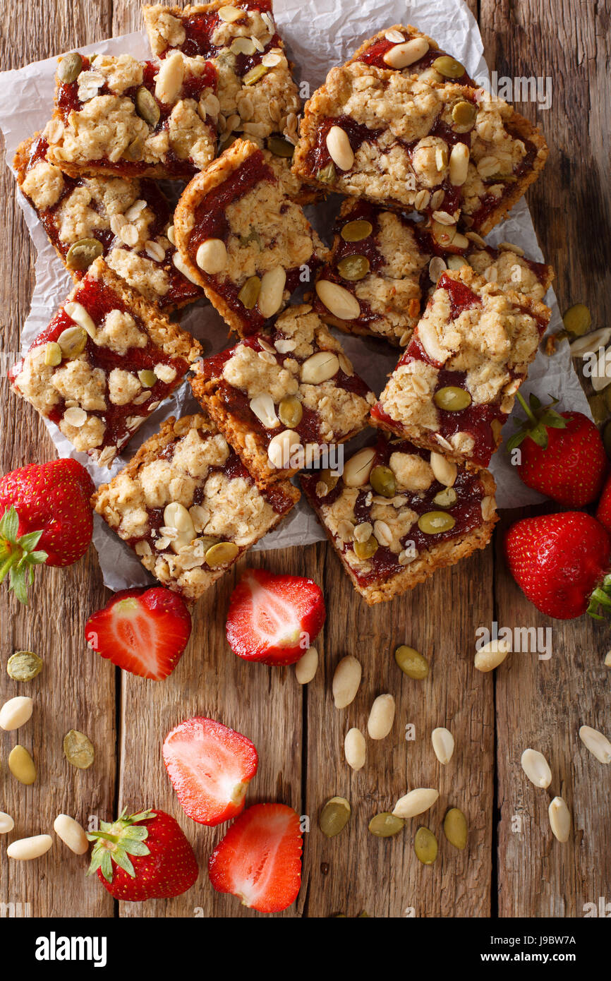 Tasty strawberry bars with oatmeal and nuts close-up on the table. Vertical view from above Stock Photo