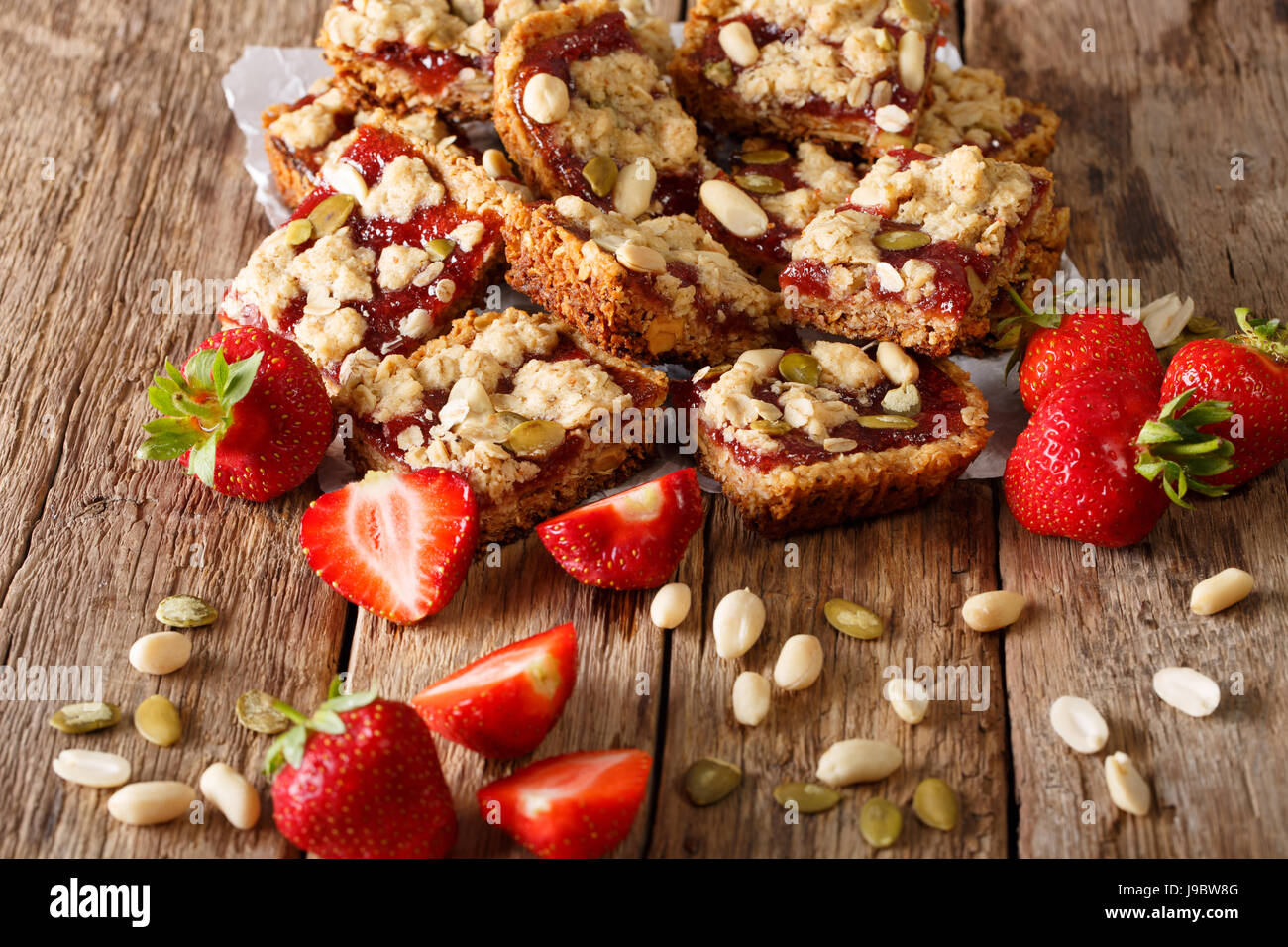 Healthy Oat bars with strawberry jam, seeds and nuts close-up on the table. horizontal Stock Photo
