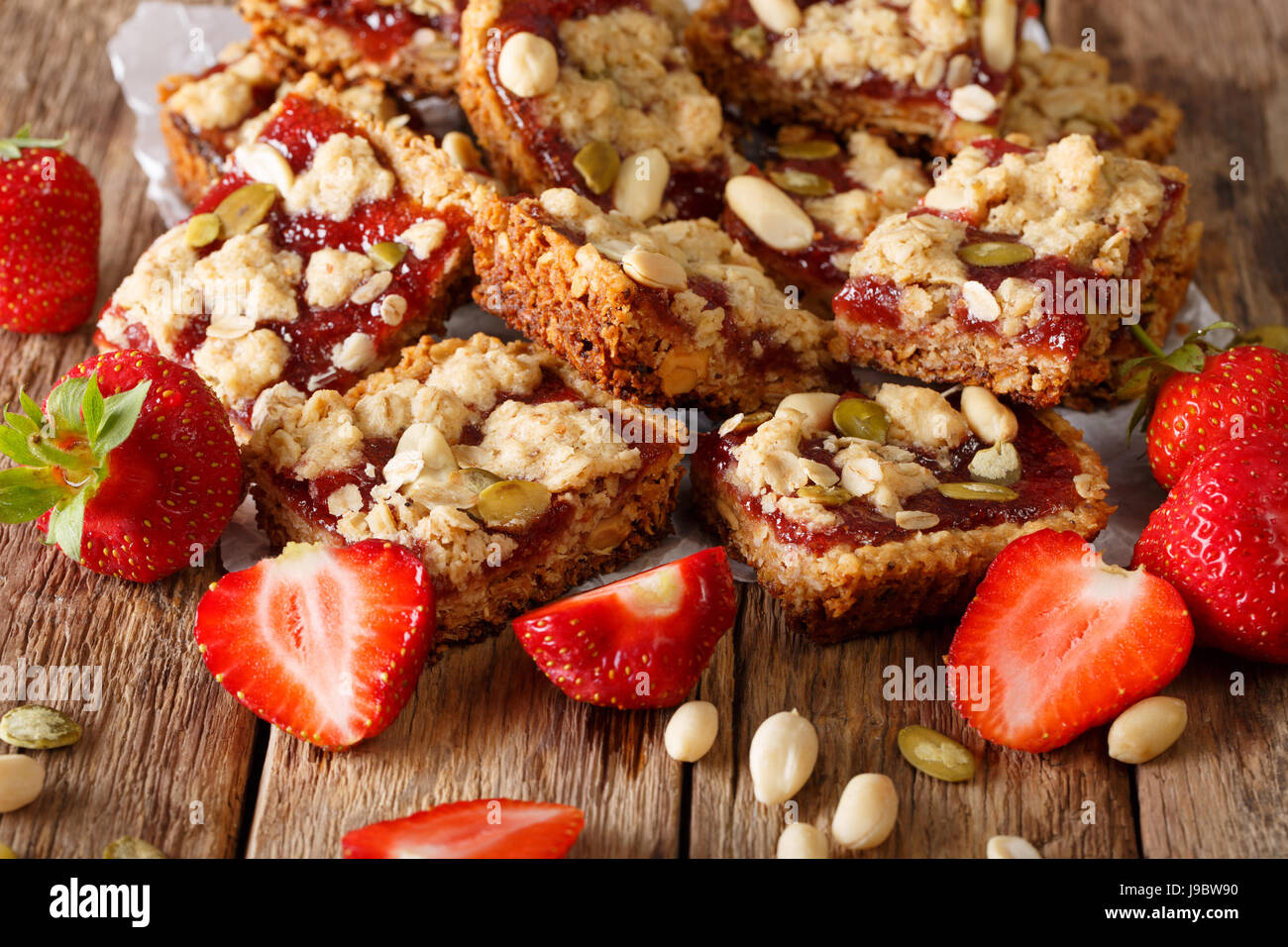 Granola bars with strawberry jam, seeds and nuts close-up on the table. Horizontal Stock Photo
