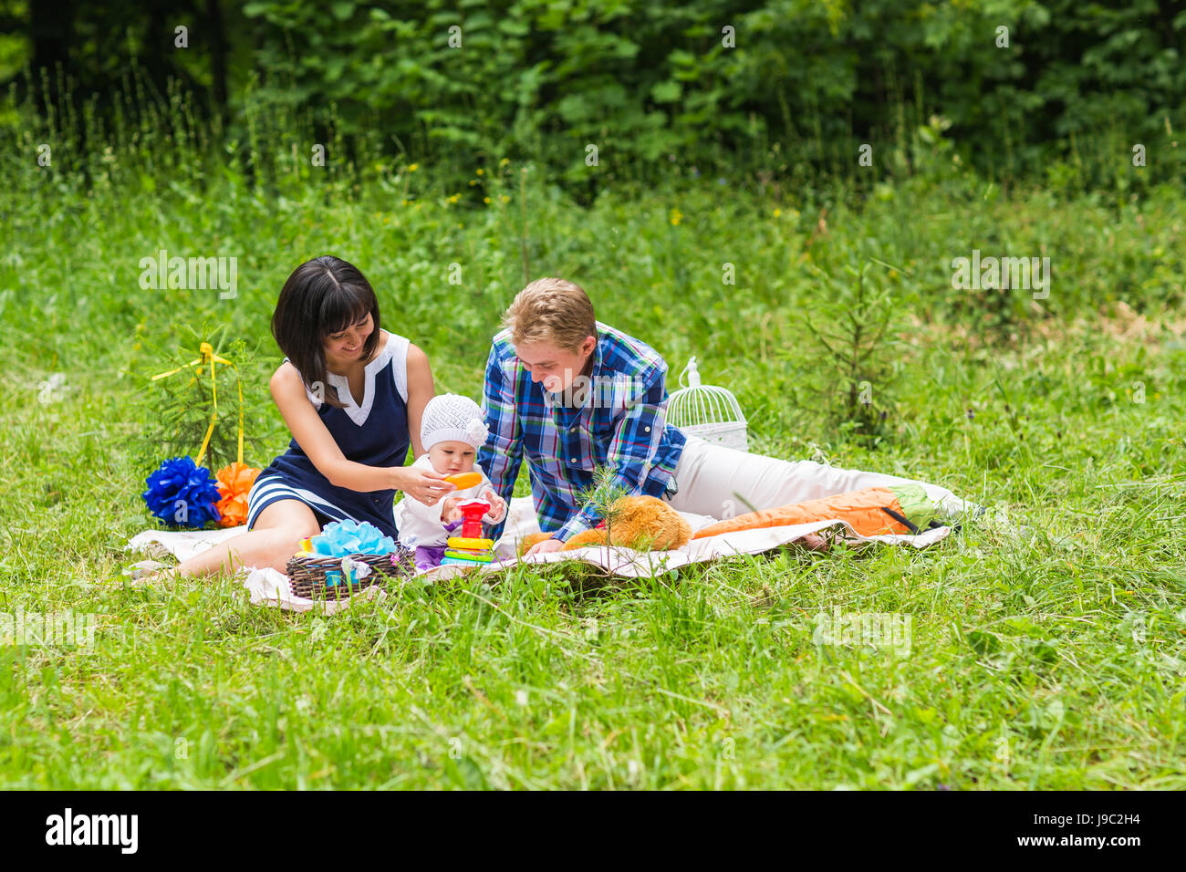 Happy Mixed Race Family Having a Picnic and Playing In The Park Stock ...