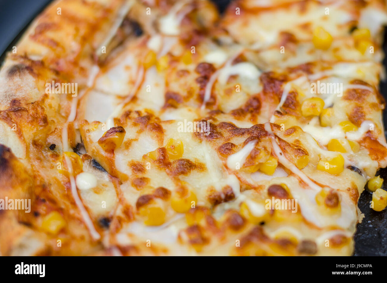 Italian style pizza and corn grain, beef, peppers and tomatoes. Close-up Pizza, blur, selective focus Stock Photo