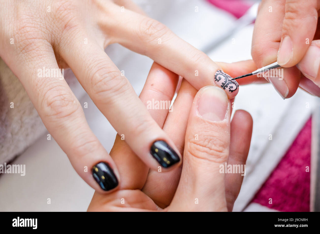 Woman applying black drawing nail polish Stock Photo