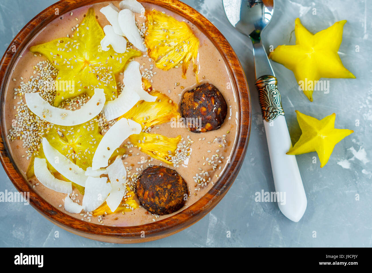 Chocolate smoothie bowl with exotic fruits and energy balls. Love for a healthy vegan food concept Stock Photo