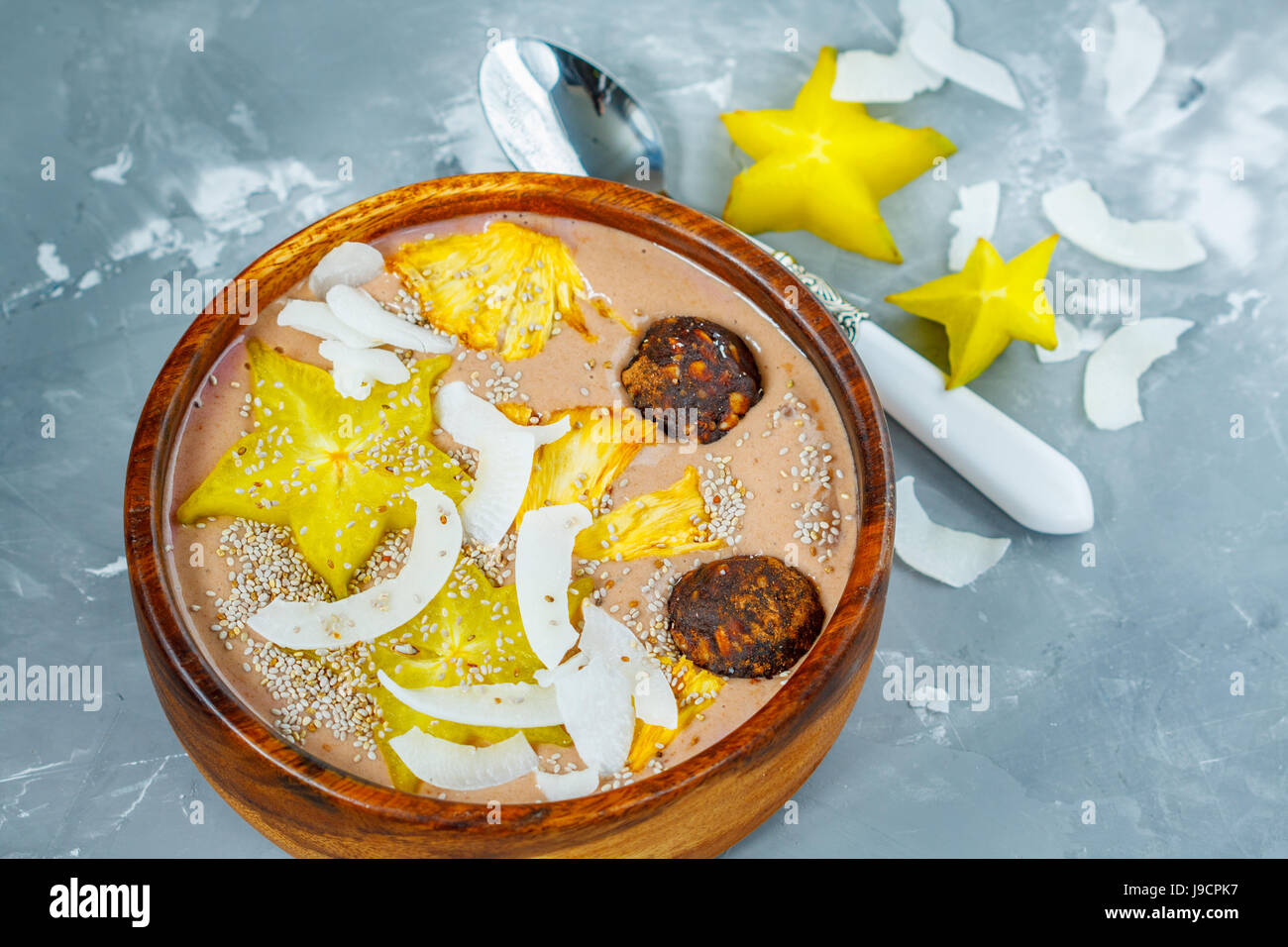 Chocolate smoothie bowl with exotic fruits and energy balls. Love for a healthy vegan food concept Stock Photo