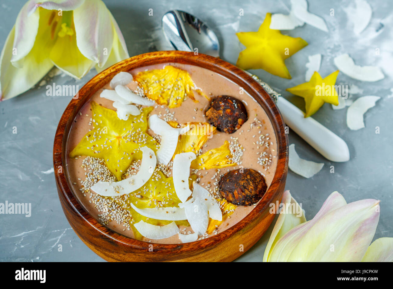 Chocolate smoothie bowl with exotic fruits and energy balls. Love for a healthy vegan food concept Stock Photo