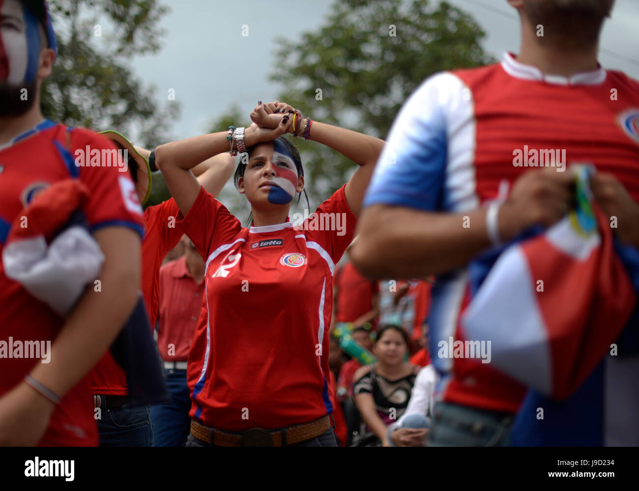 A Costa Rica fan watches anxiously as the Costa Rican national soccer team takes on Uruguay in the 2014 World Cup. Stock Photo