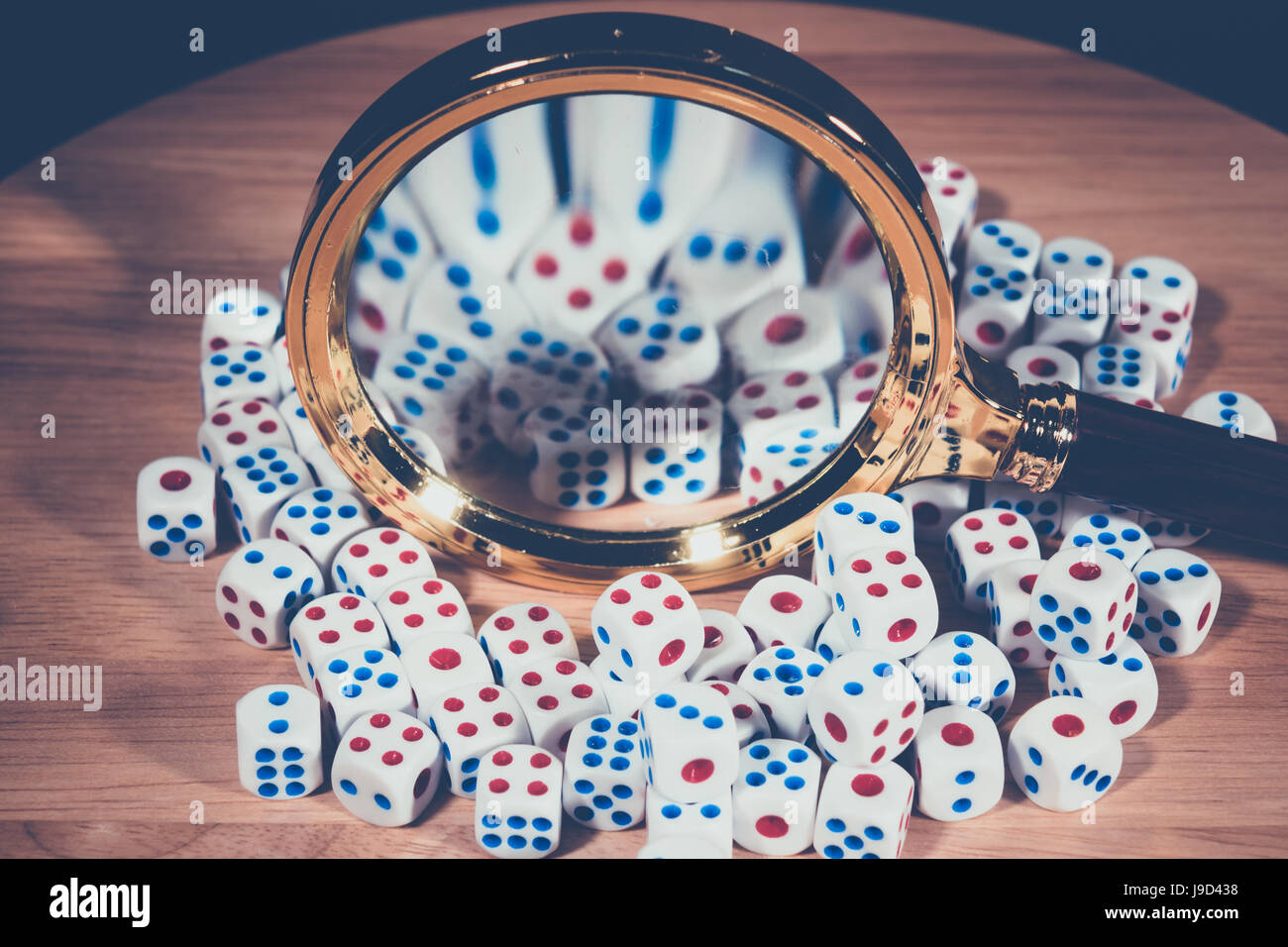 A magnifying glass with many dice Stock Photo Alamy