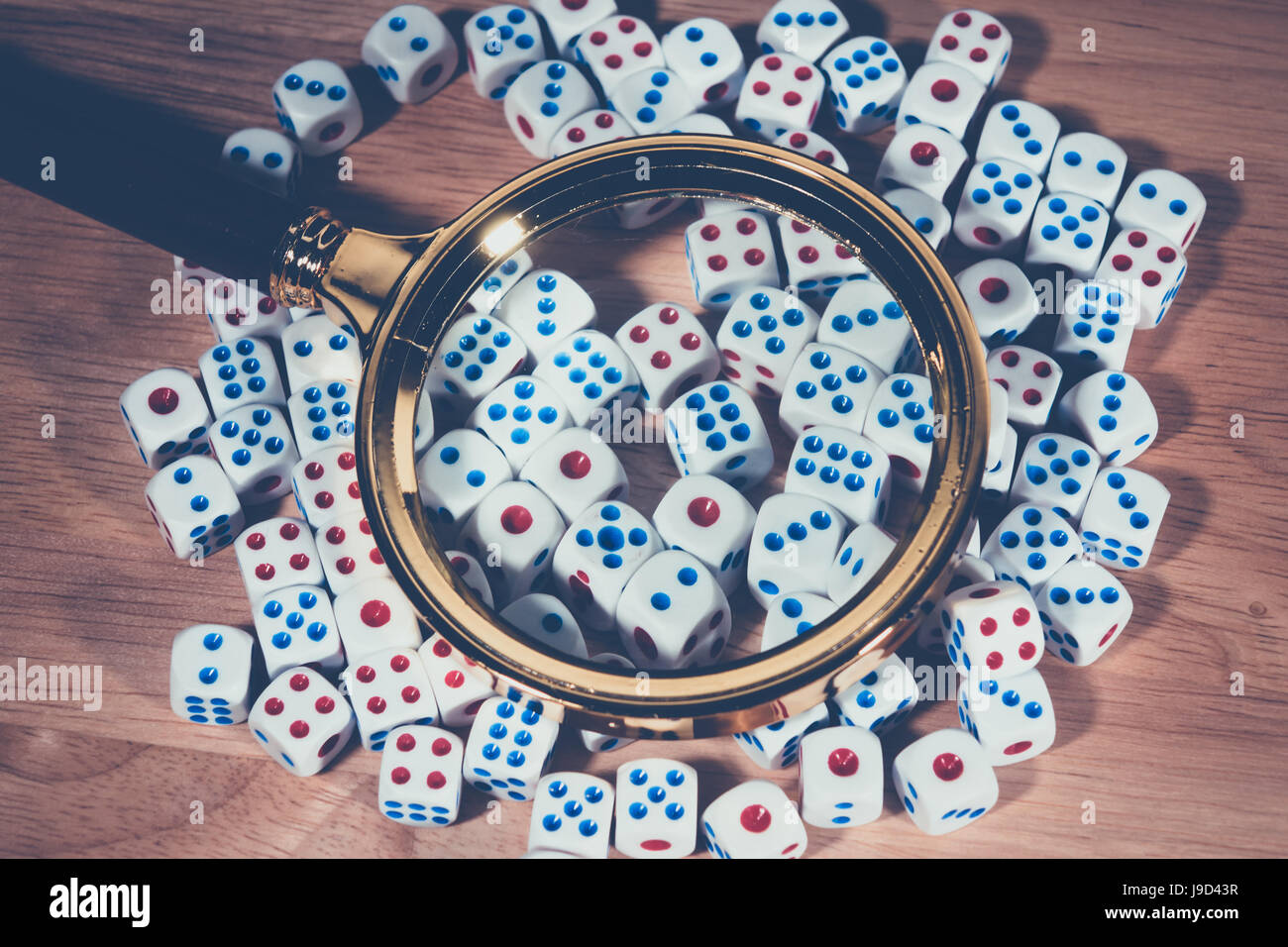 A magnifying glass with many dice Stock Photo Alamy