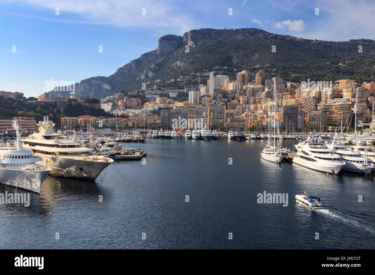 Pastel hues of the glamorous harbour of Monaco (Port Hercules) with many yachts, viewed from the sea, Monte Carlo, Cote d'Azur Stock Photo