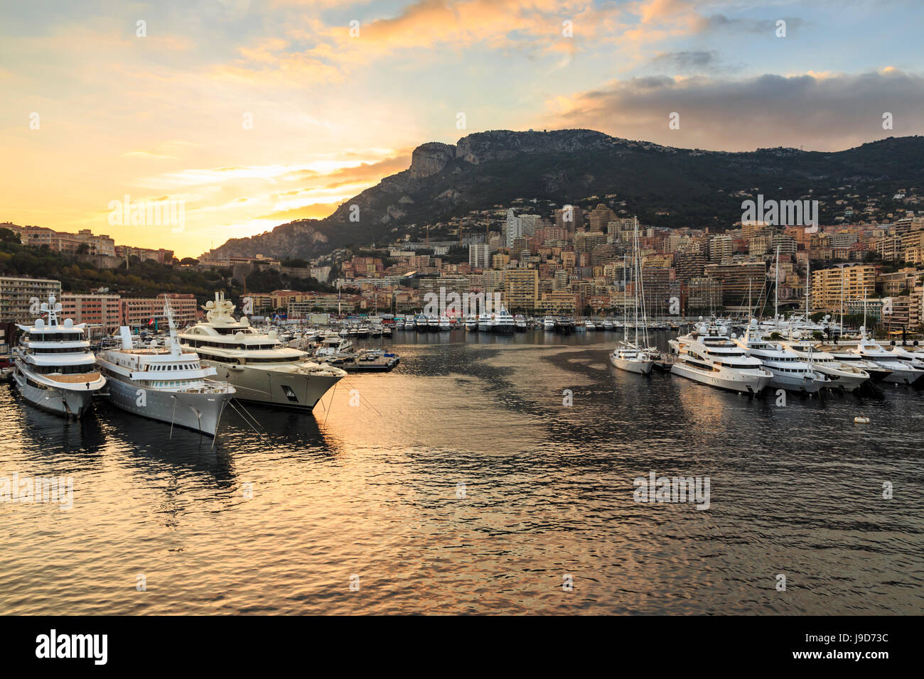 Vivid sunset over super yachts, glamorous harbour of Monaco (Port Hercules), from the sea, Monte Carlo, Monaco, Cote d'Azur Stock Photo