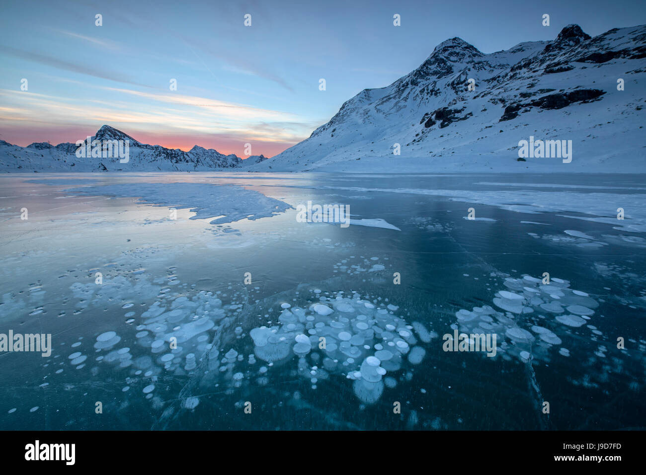 Ice bubbles frame the snowy peaks reflected in Lago Bianco, Bernina Stock  Photo - Alamy