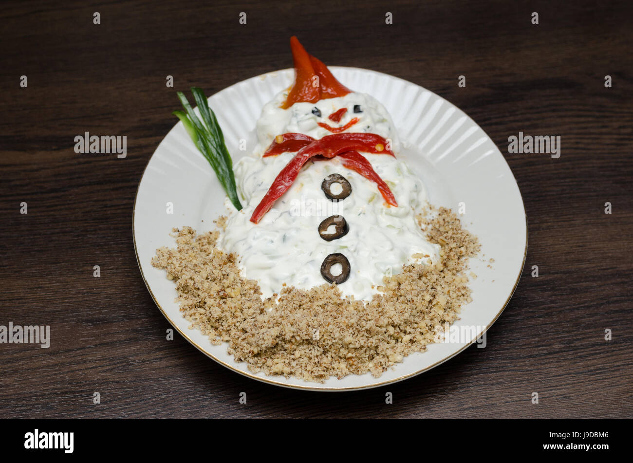 Funny snowman made of white souce in plate Stock Photo