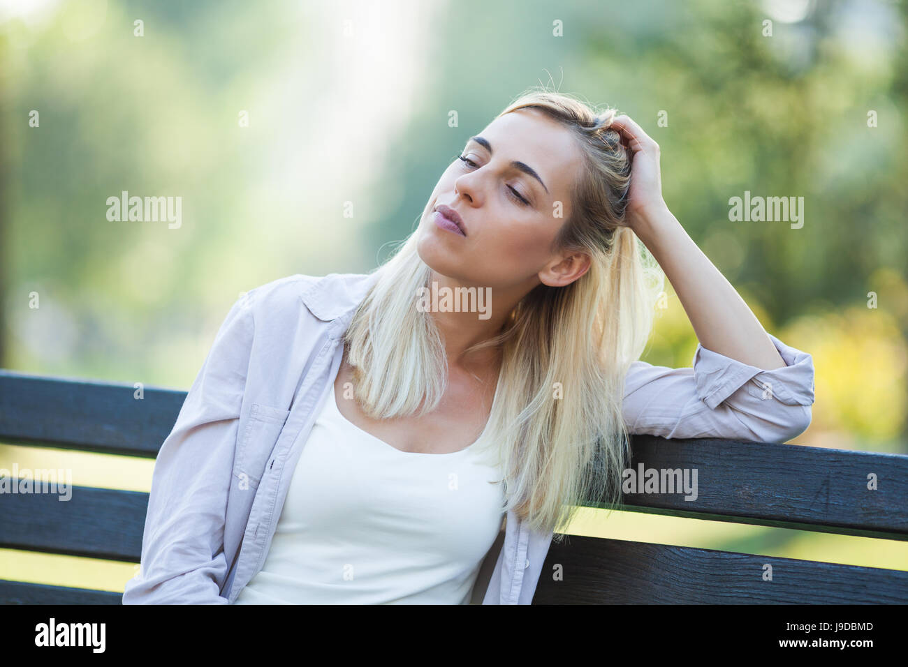 Lonely woman sitting in park in despair. Stock Photo