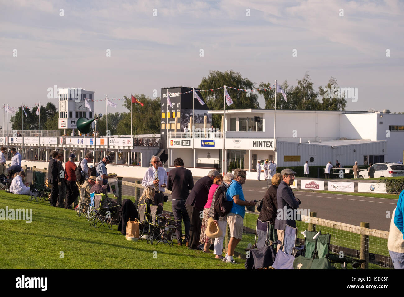 Spectators standing and sitting alongside the circuit at the 2015 goodwood revival. Stock Photo