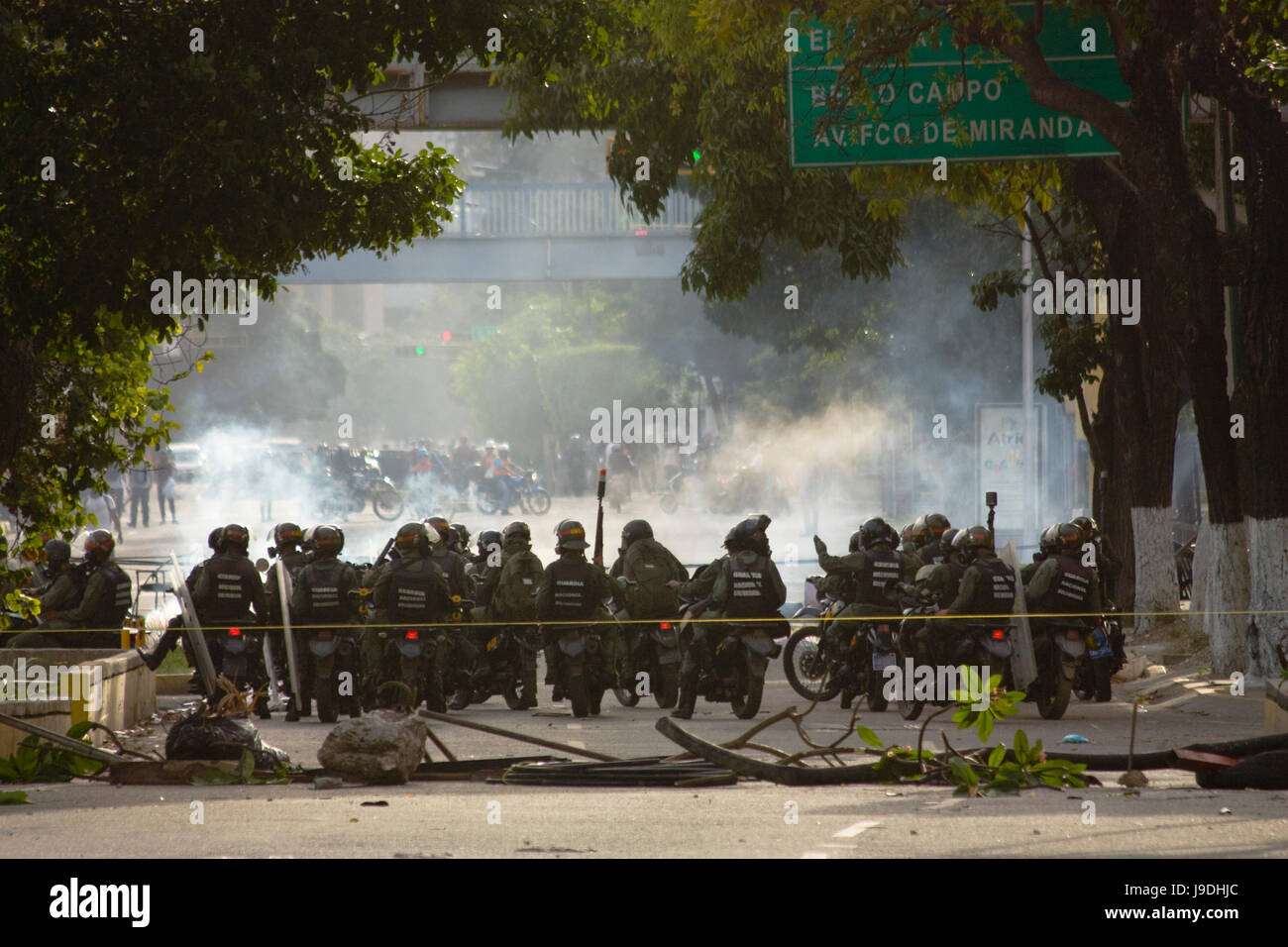 Members of the Bolivarian National Guard using motorcycles clash with opposition protesters to the government of Nicolas Maduro in Caracas. Stock Photo