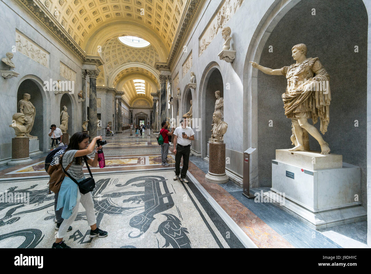 Rome. Italy. Visitor photographing Augustus of Prima Porta statue in the Braccio Nuovo Sculpture Gallery, Chiaramonti Museum, Vatican Museums. Musei V Stock Photo