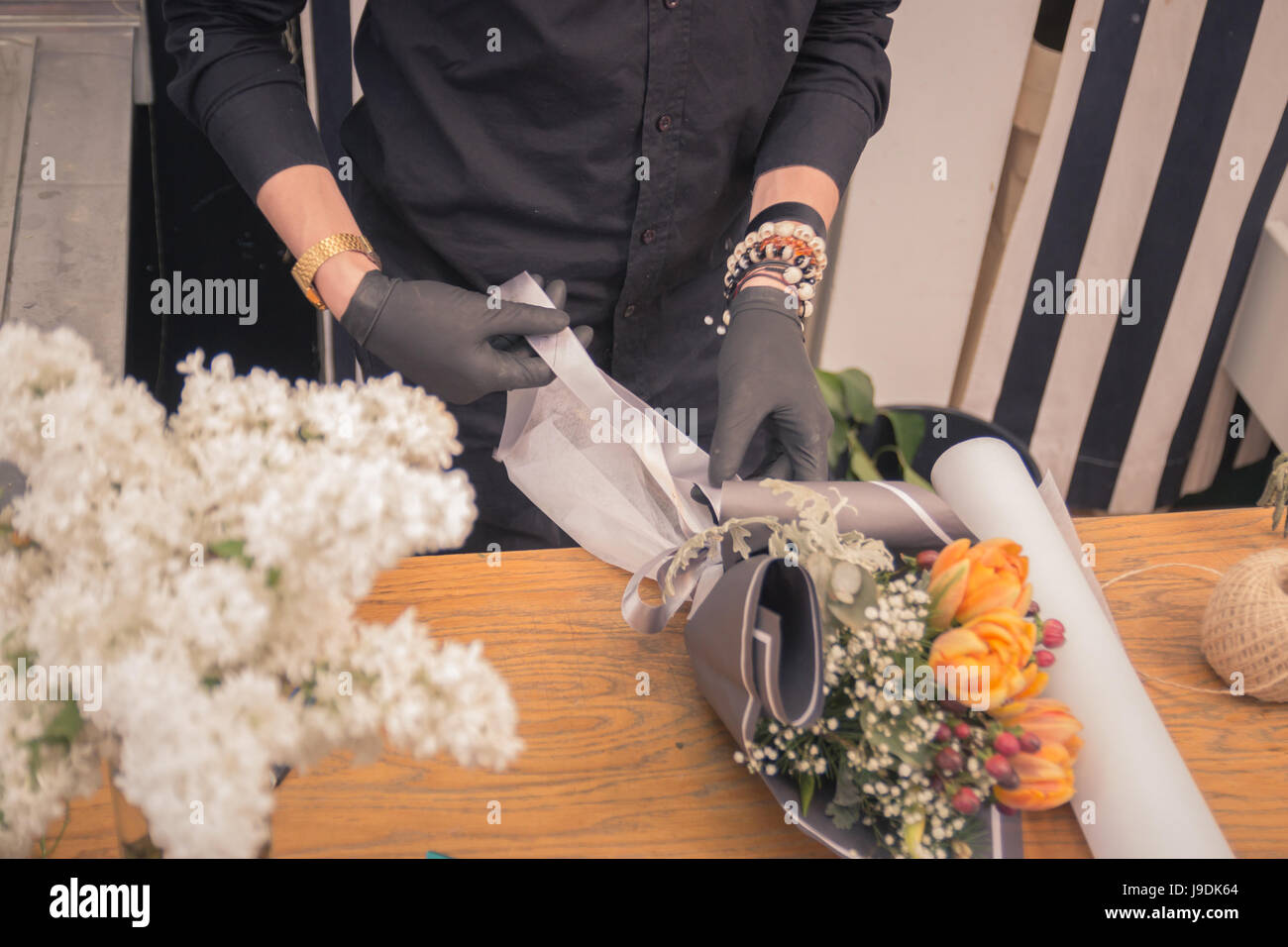one florist, hands closeup, working making arranging flower bouquet, flower shop, indoors Stock Photo