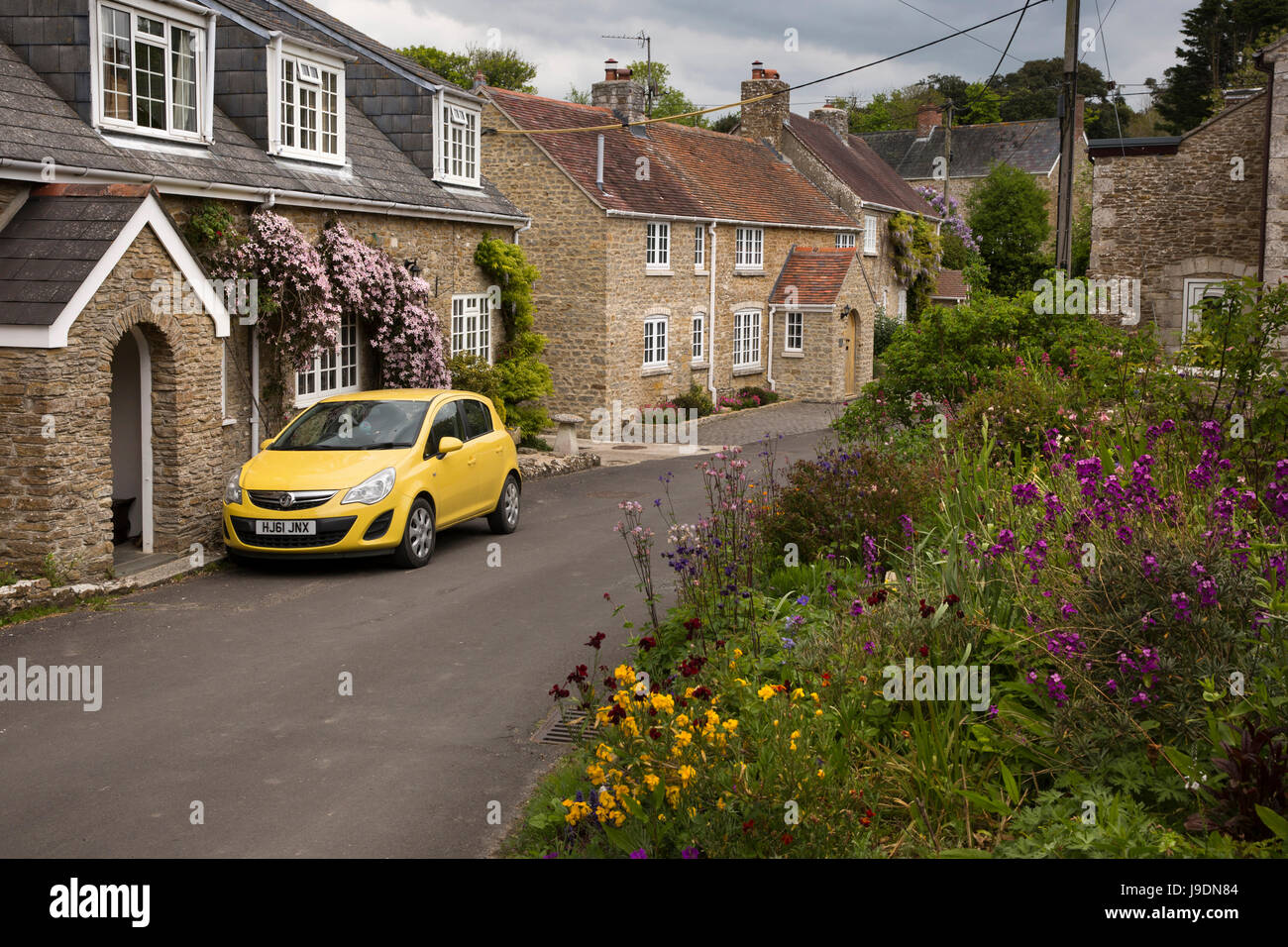 UK England, Dorset, Langton Herring, The Square, yellow Vauxhall car parked on street outside
