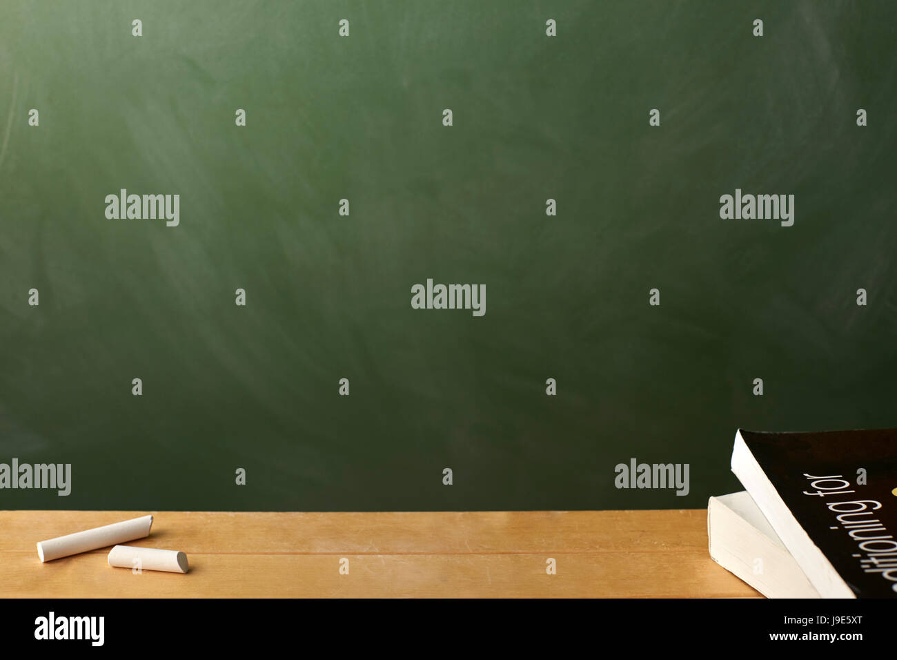 School text book and chalk on desk in front of chalkboard Stock Photo ...