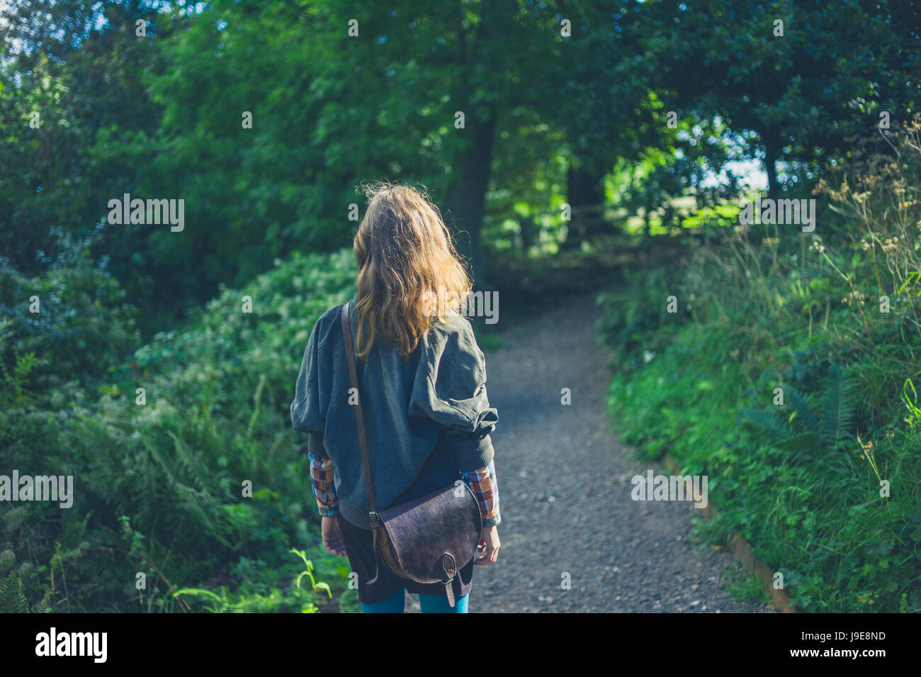 A young woman is walking in a forest in autumn Stock Photo - Alamy