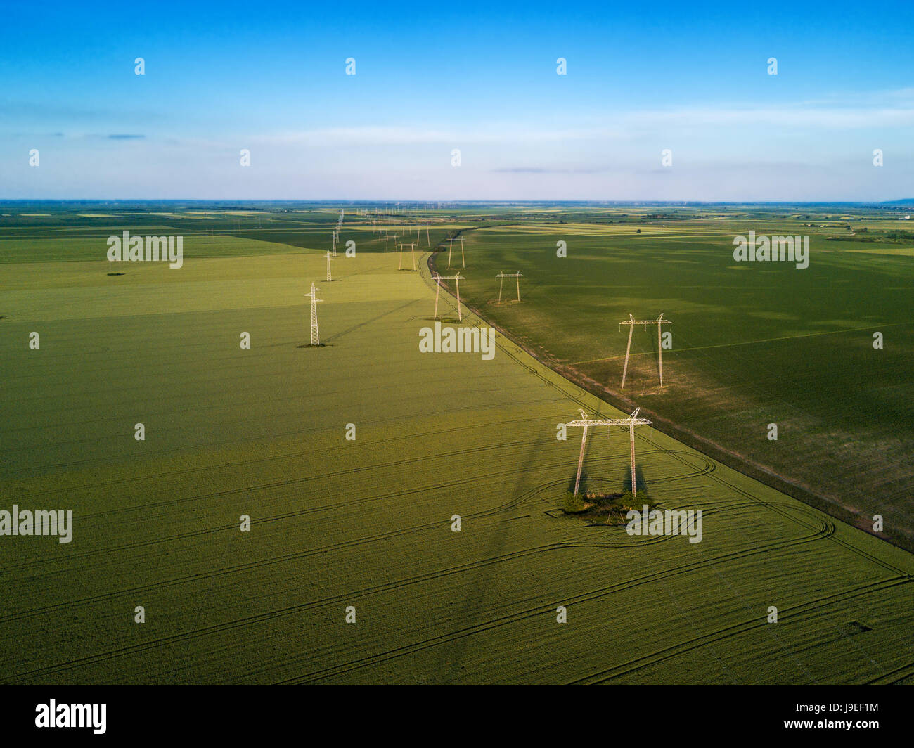 Aerial view of overhead electricity power line pylons in plain landscape Stock Photo