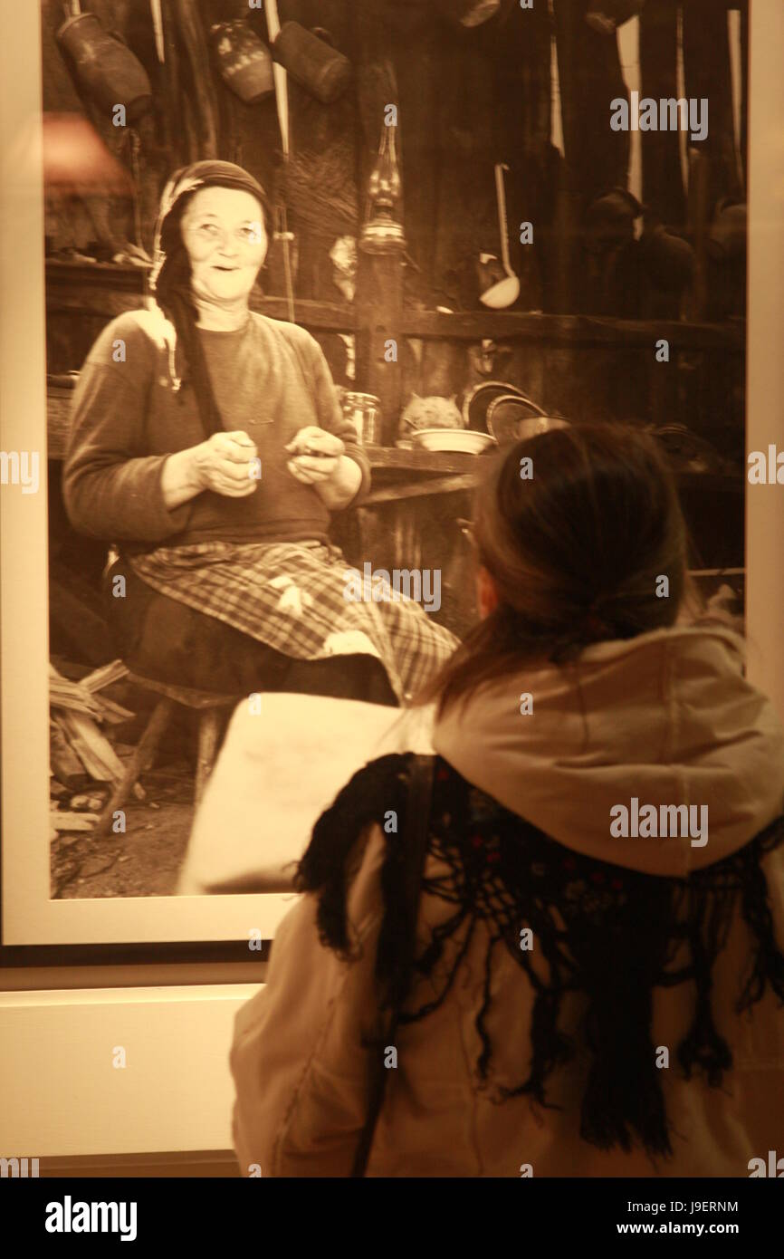 People looking at art display in gallery. Photography show by Emanuel Tanjala featuring pictures from Romania. Stock Photo