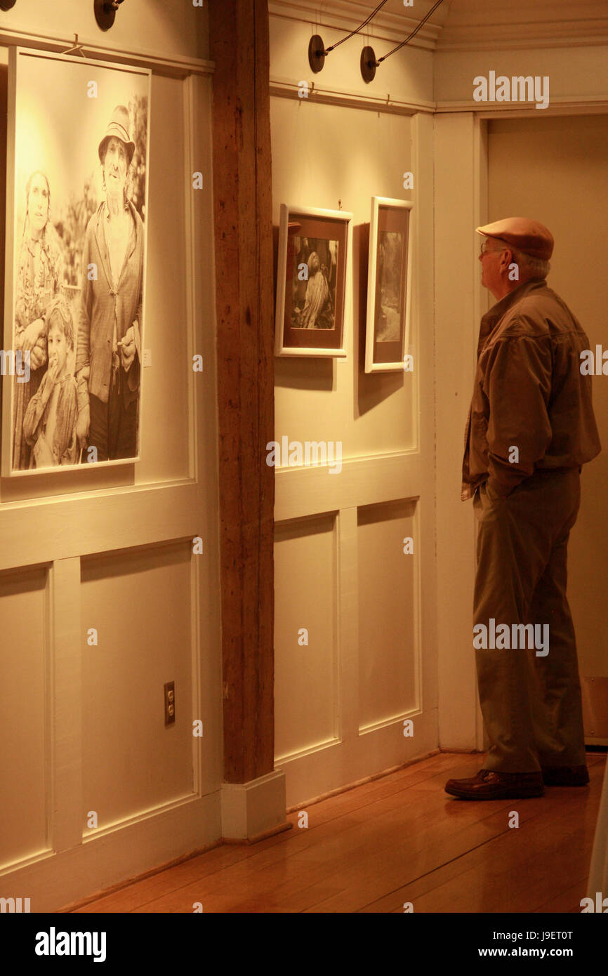 People looking at art display in gallery. Photography show by Emanuel Tanjala featuring pictures from Romania. Stock Photo