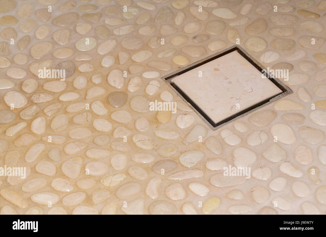 Shower drain box grate in stone cladding floor. Shower drain box grate