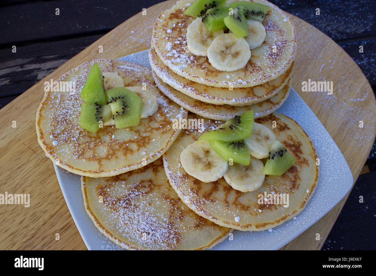 Selection Of Pancakes With White Sugar Kiwi And Sliced Bananas