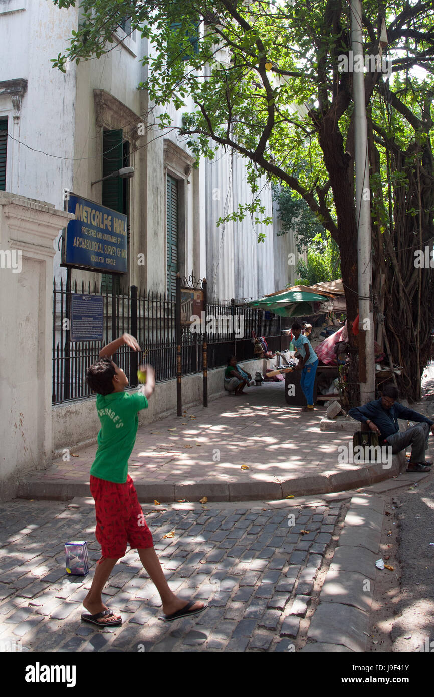 Boys playing cricket in the street outside Metcalfe Hall, Kolkata India Stock Photo