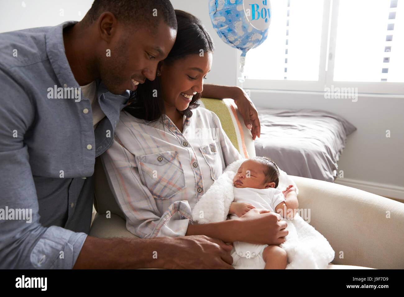 Parents Home from Hospital With Newborn Baby In Nursery Stock Photo