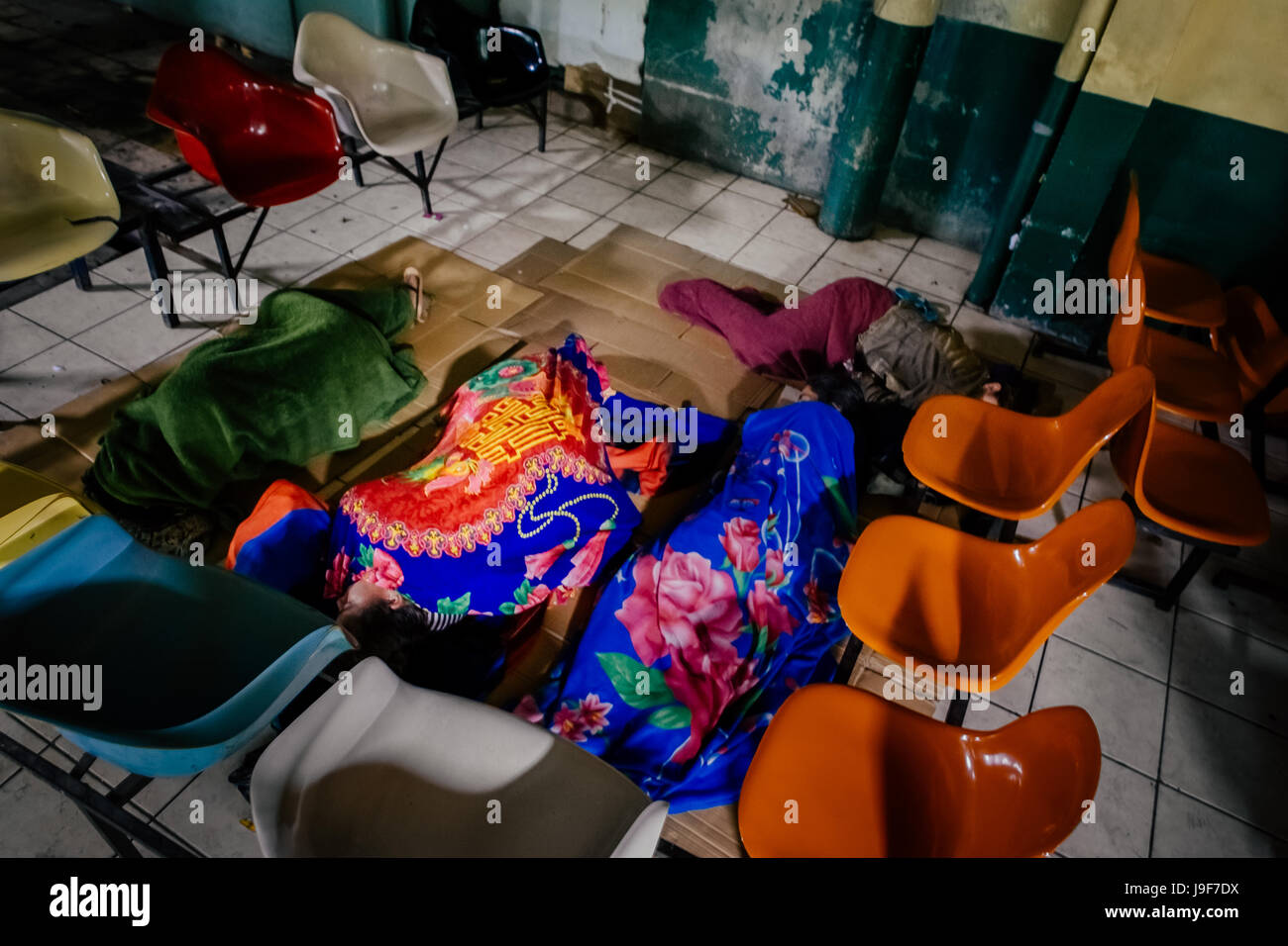 Patients’ family members sleep on the floor in a patio inside the emergency department of a public hospital in San Salvador, El Salvador, 16 December 2015. Stock Photo