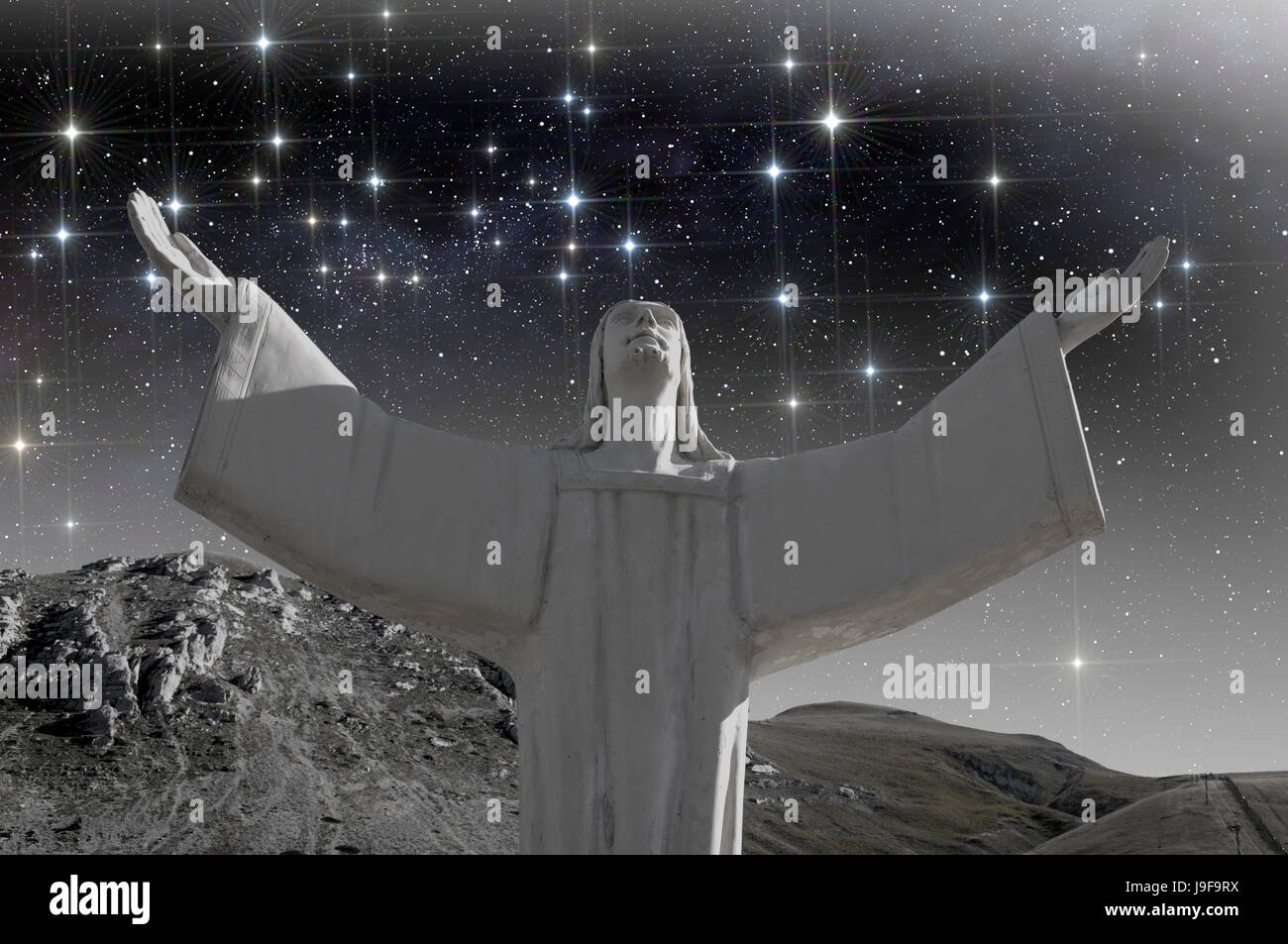 Christ with oper arms under starry sky Stock Photo