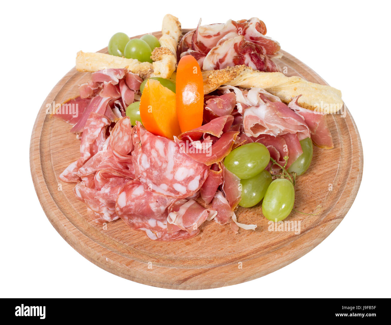 Mixed italian dried meats platter with croutons and grapes. Isolated on a white background. Stock Photo