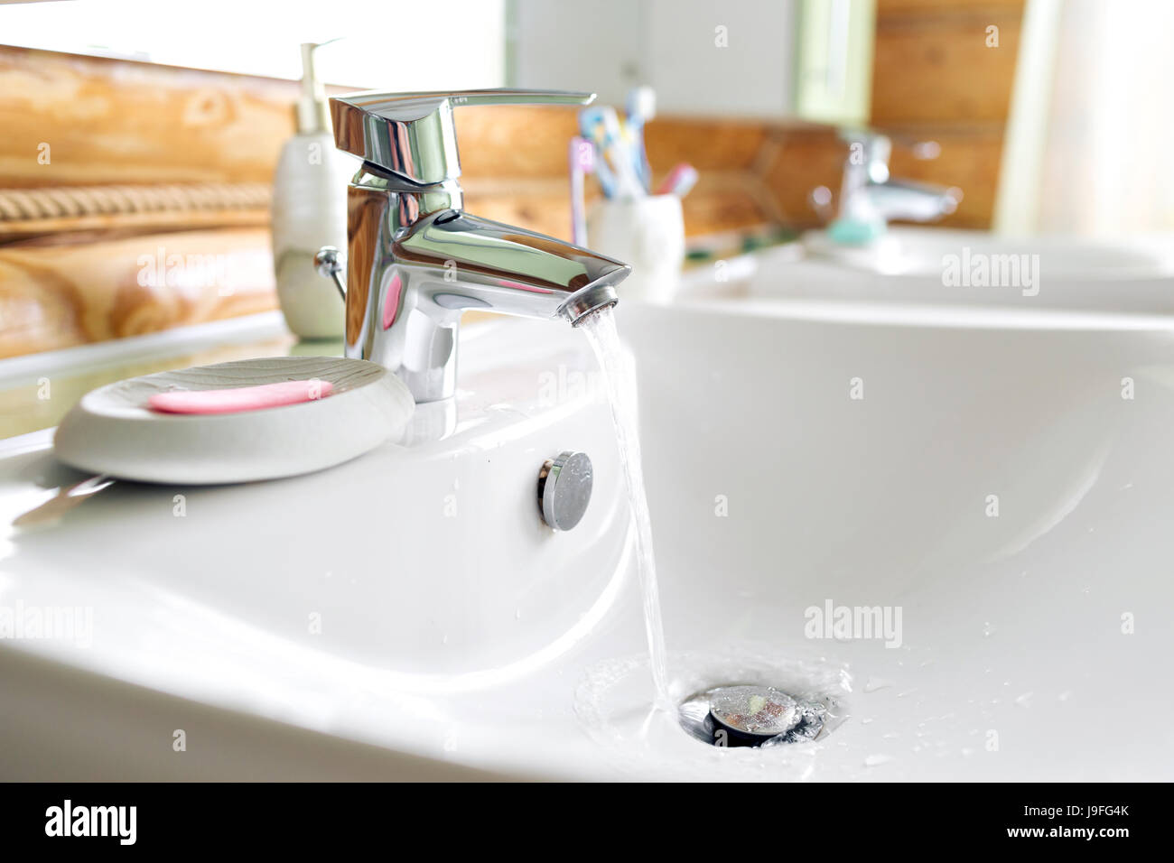 Working mixer tap in the bathroom closeup. water flows into the sink