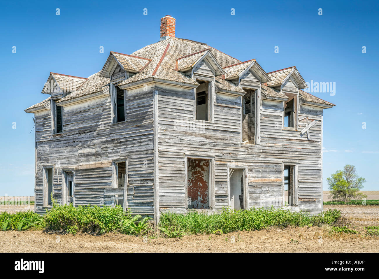 abandoned old house in rural Nebraska in the middle of a field Stock