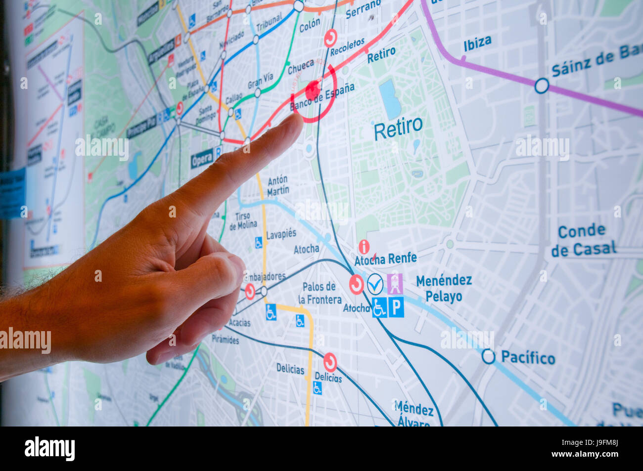 Man's hand pointing at a point on a Metro map. Madrid, Spain. Stock Photo