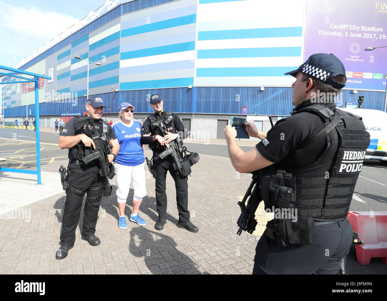 A Cardiff City fan has her photograph taken with armed police outside ...