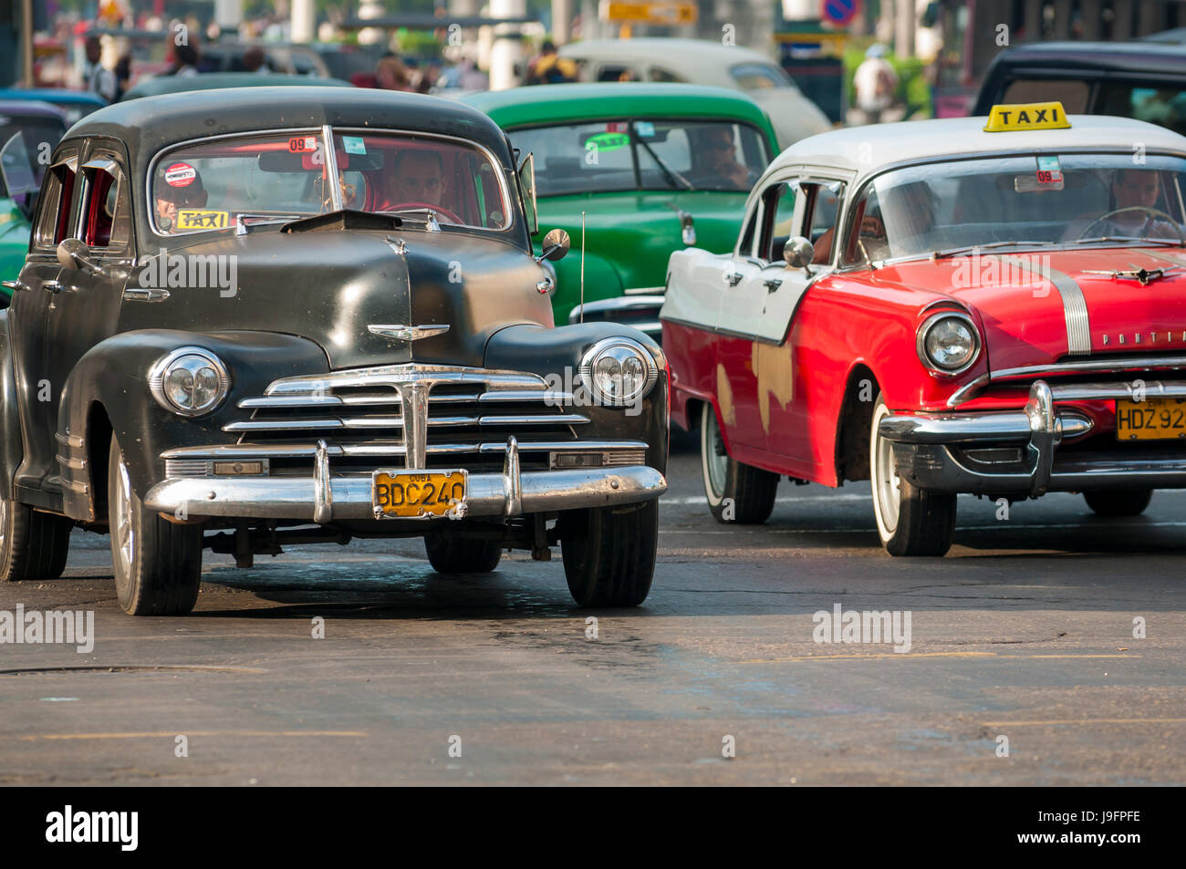 HAVANA, CUBA - CIRCA JUNE, 2011: Vintage American taxi cars share the road on a street in Centro. Stock Photo