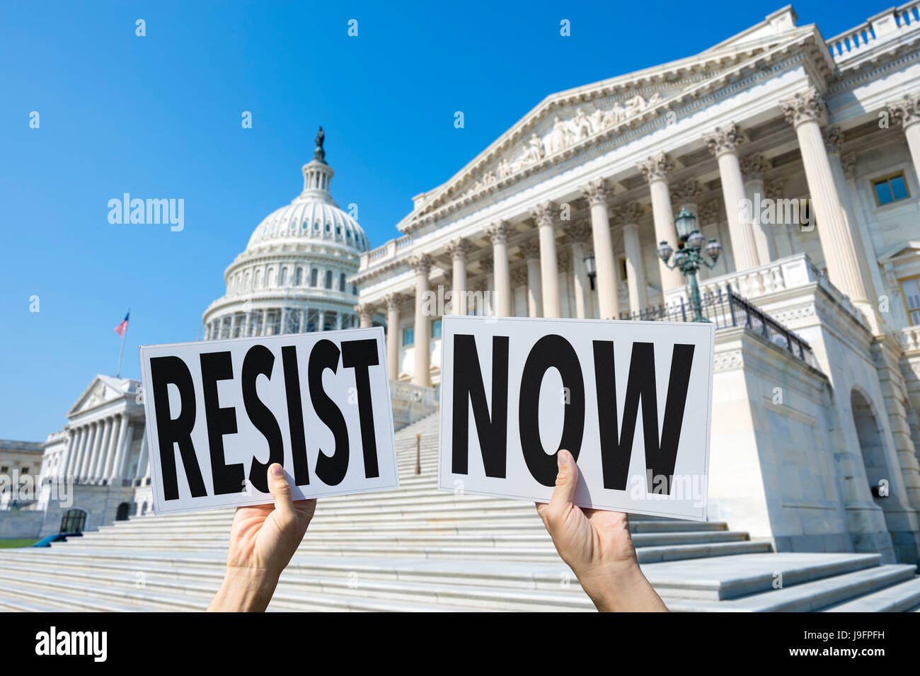 Hands of protesters in Washington, DC holding up signs urging their representatives on Capitol Hill to RESIST NOW, referring to the White House Stock Photo