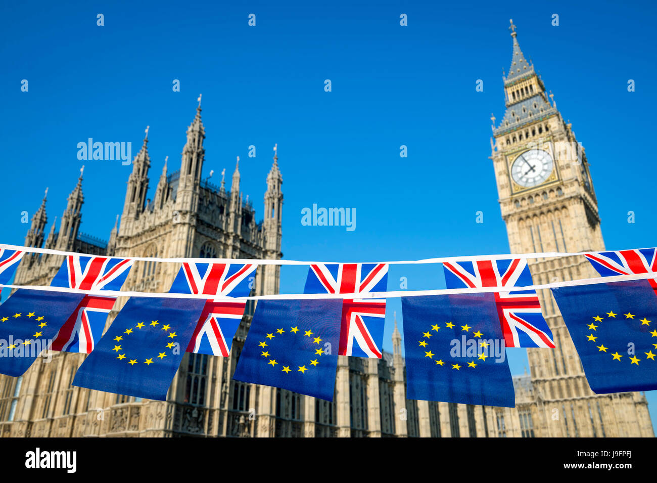 European Union and United Kingdom flag Brexit bunting hanging together in front of Big Ben and the Houses of Parliament at Westminster Palace Stock Photo