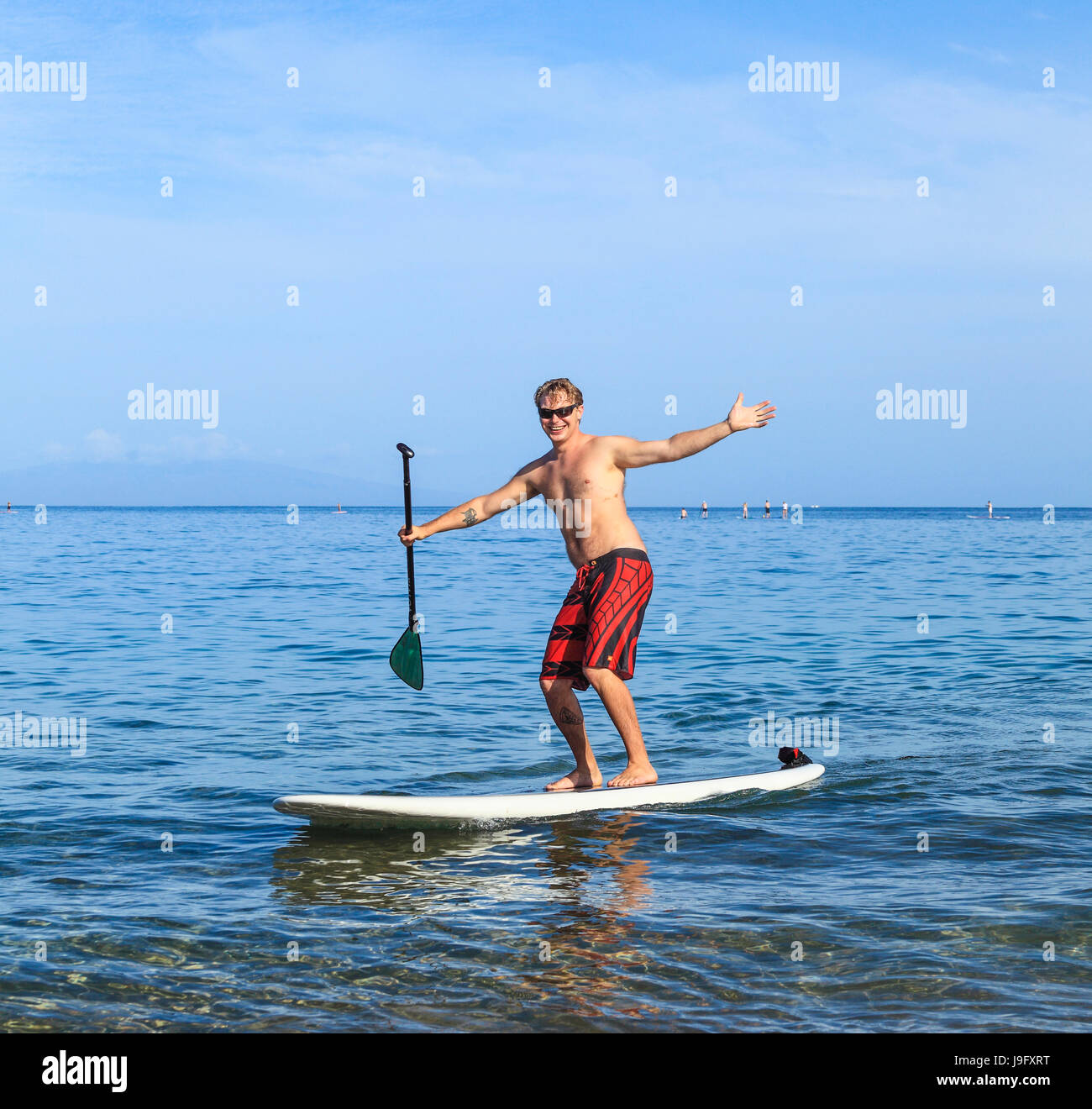 Man enjoying stand up padding expresses happiness at Wailea Beach on Maui Stock Photo