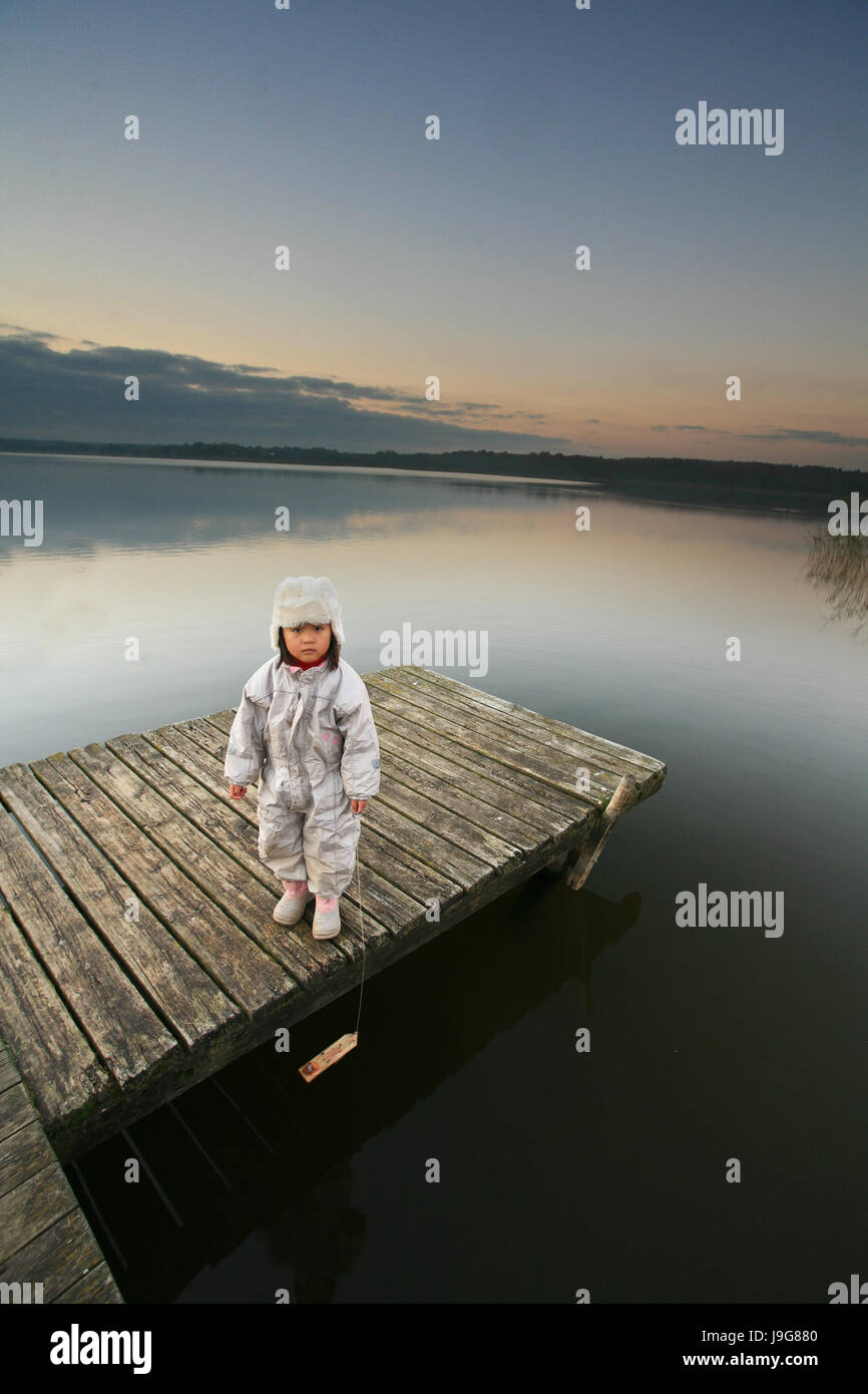 Child in winter and View on a beautiful  lake landscape  in scandinavia in denmark Stock Photo